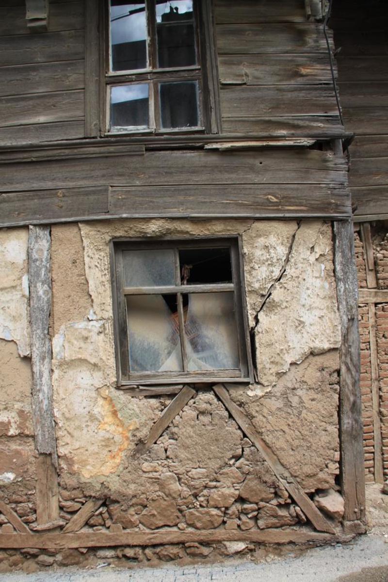 Resim 5. Edincik, Kubbealtı Caddesi’ndeki üç katlı ahşap karkas binanın zemin katındaki ahşap dikme ve çaprazlar ile dolgu elemanı olarak kullanılan taş ve tuğla yapı malzemeleri, 7 Nisan 2024.